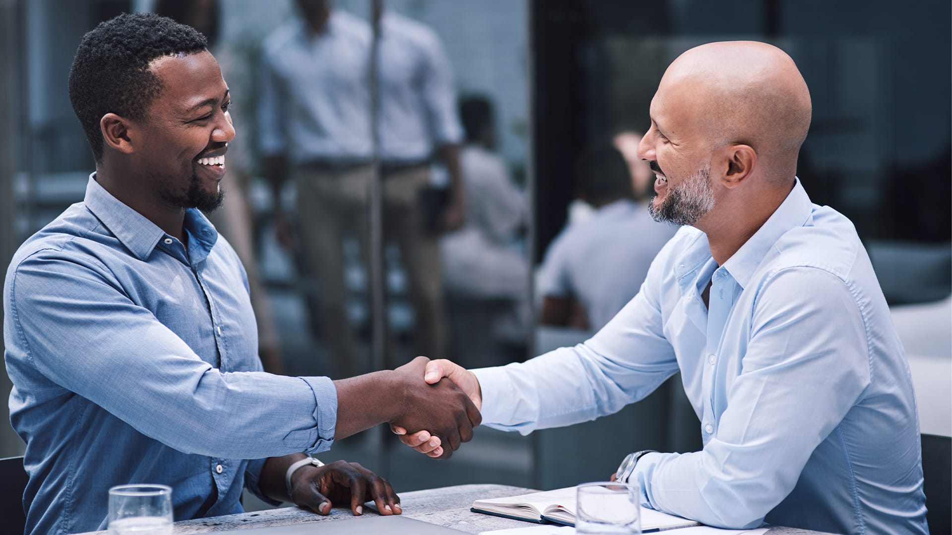 A man happily shaking his collection agent after successfully negotiating with the collections agency